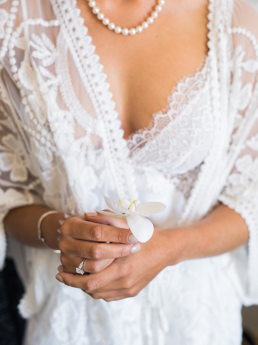La mariée prend une fleur dans sa main quelques heures avant le debut de la cérémonie de mariage à Cannes sur la Côte d'Azur.