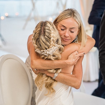 A mother hugs her daughter at a wedding cocktail party in France