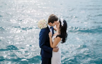 A bride and groom share a romantic kiss by the sparkling water of Lake Geneva, captured by their wedding photographer in Geneva.