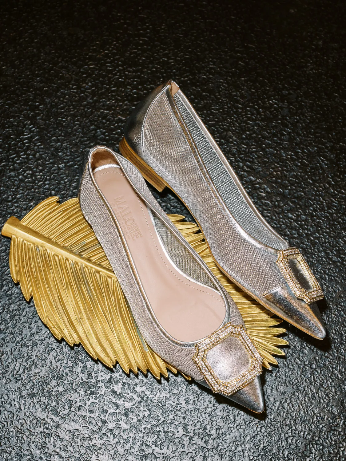 Elegant silver Malone Souliers bridal shoes with crystal buckle displayed on a golden leaf tray - detail by wedding photographer Provence.