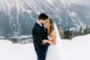 Romantic close-up of bride and groom kissing during snowfall in the French Alps - photo by wedding photographer Chamonix.