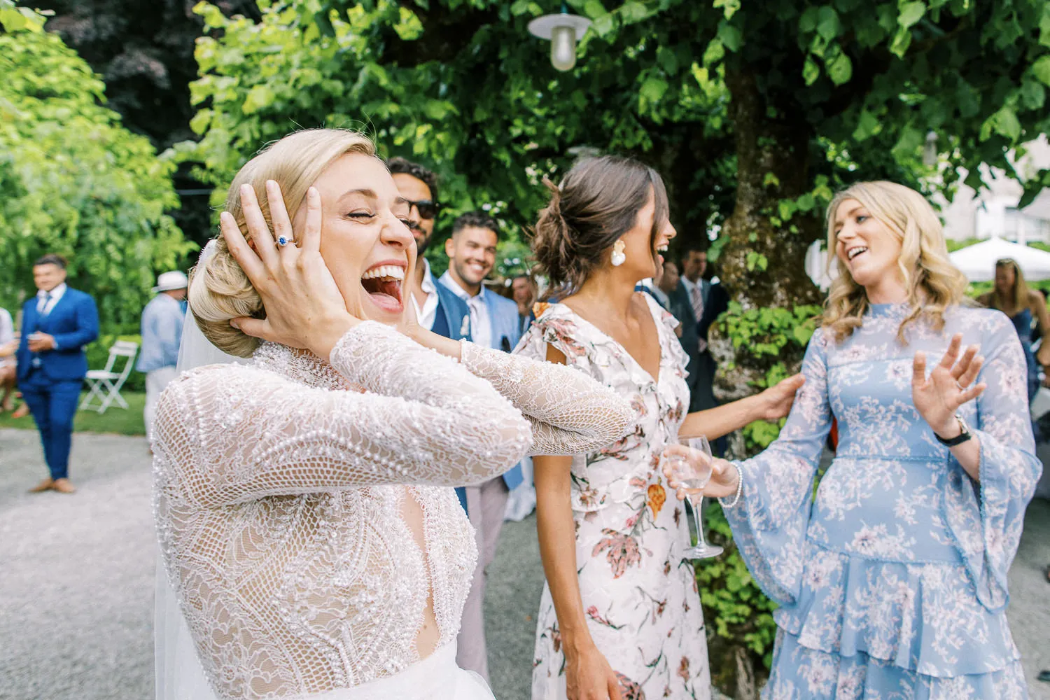 Candid photo of a bride laughing joyfully with female guests at an outdoor French Riviera wedding reception - by wedding photographer French Riviera.