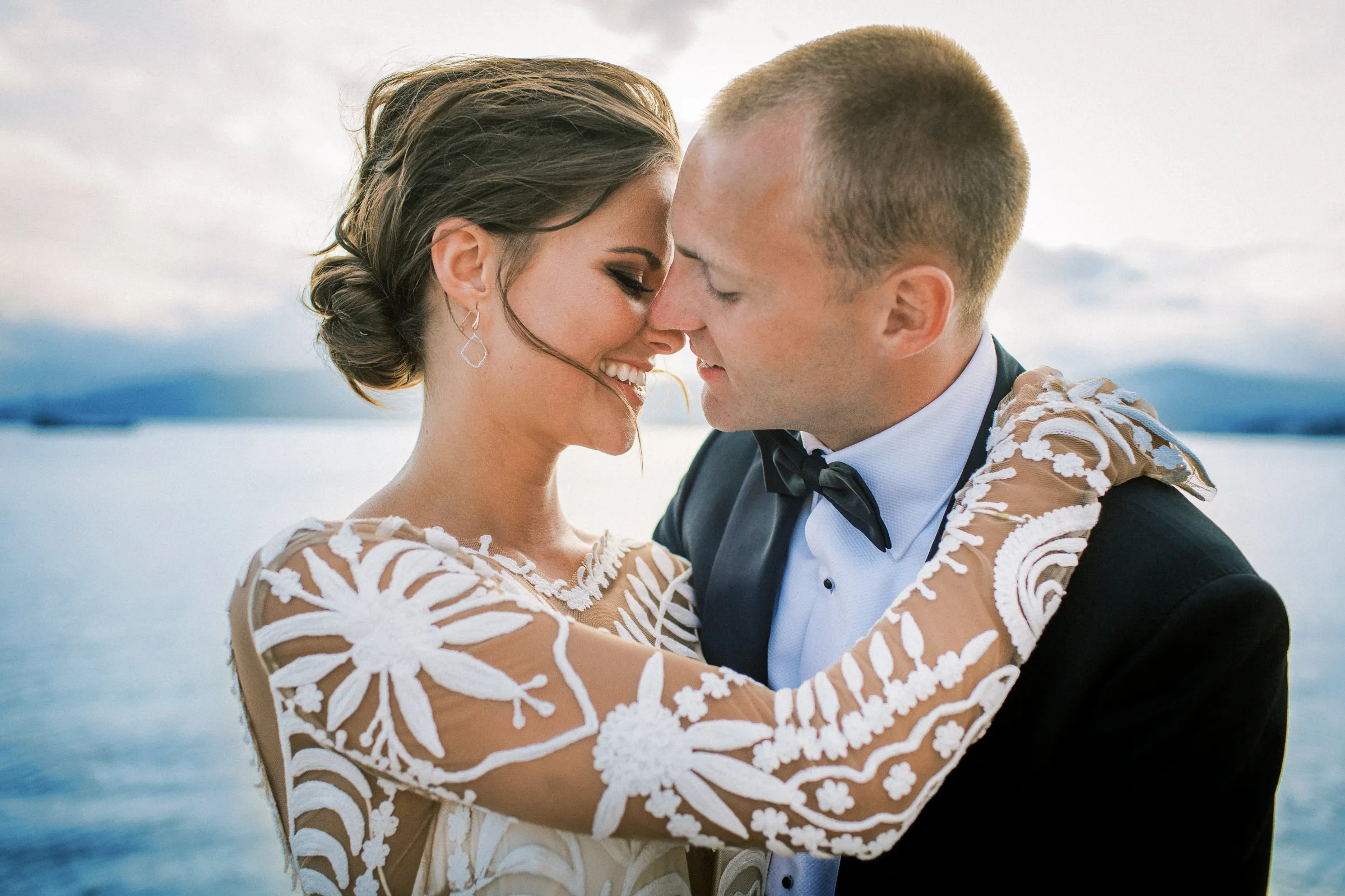 Romantic close-up of bride and groom touching foreheads by the water near Geneva - intimate photography by wedding photographer Geneva.