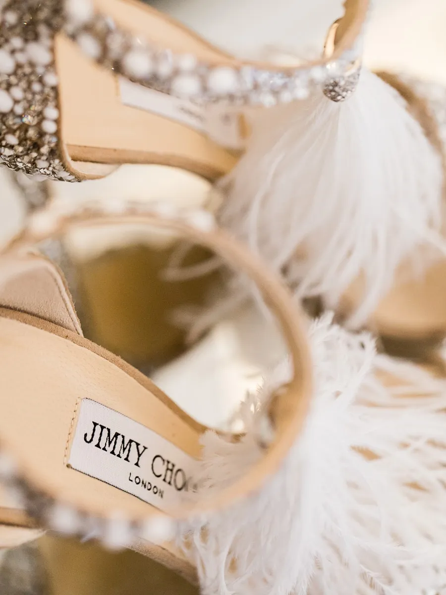 Close-up of luxury Jimmy Choo wedding shoes with feathers and crystals - detail shot by wedding photographer Geneva.
