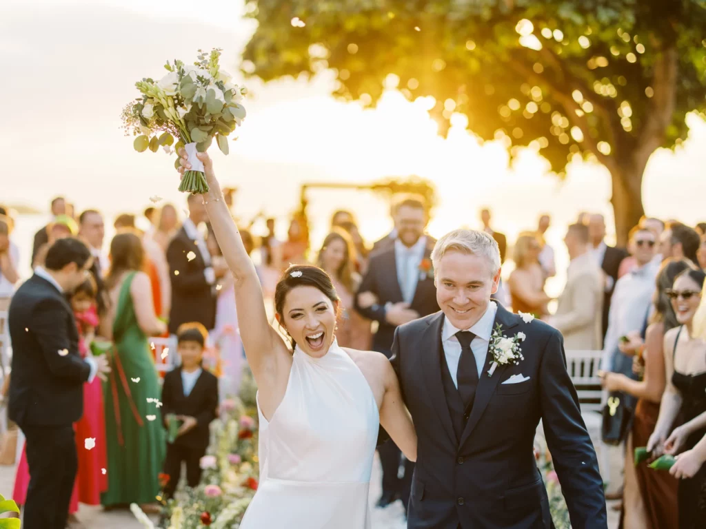 Joyful bride and groom walking down the aisle after their beach ceremony in Lombok - photo by wedding photographer Lombok.