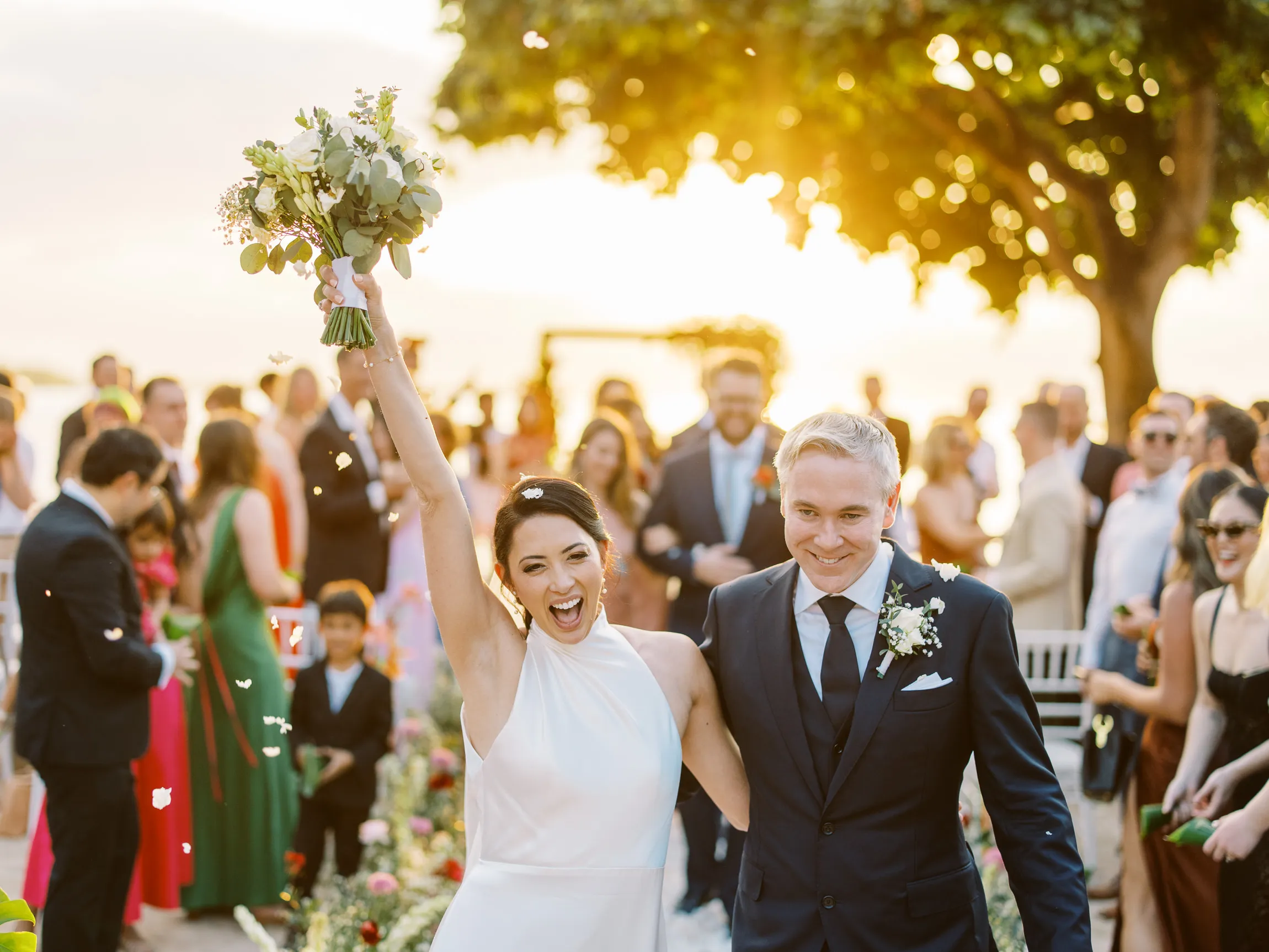 Joyful bride and groom walking down the aisle after their beach ceremony in Lombok - photo by wedding photographer Lombok.