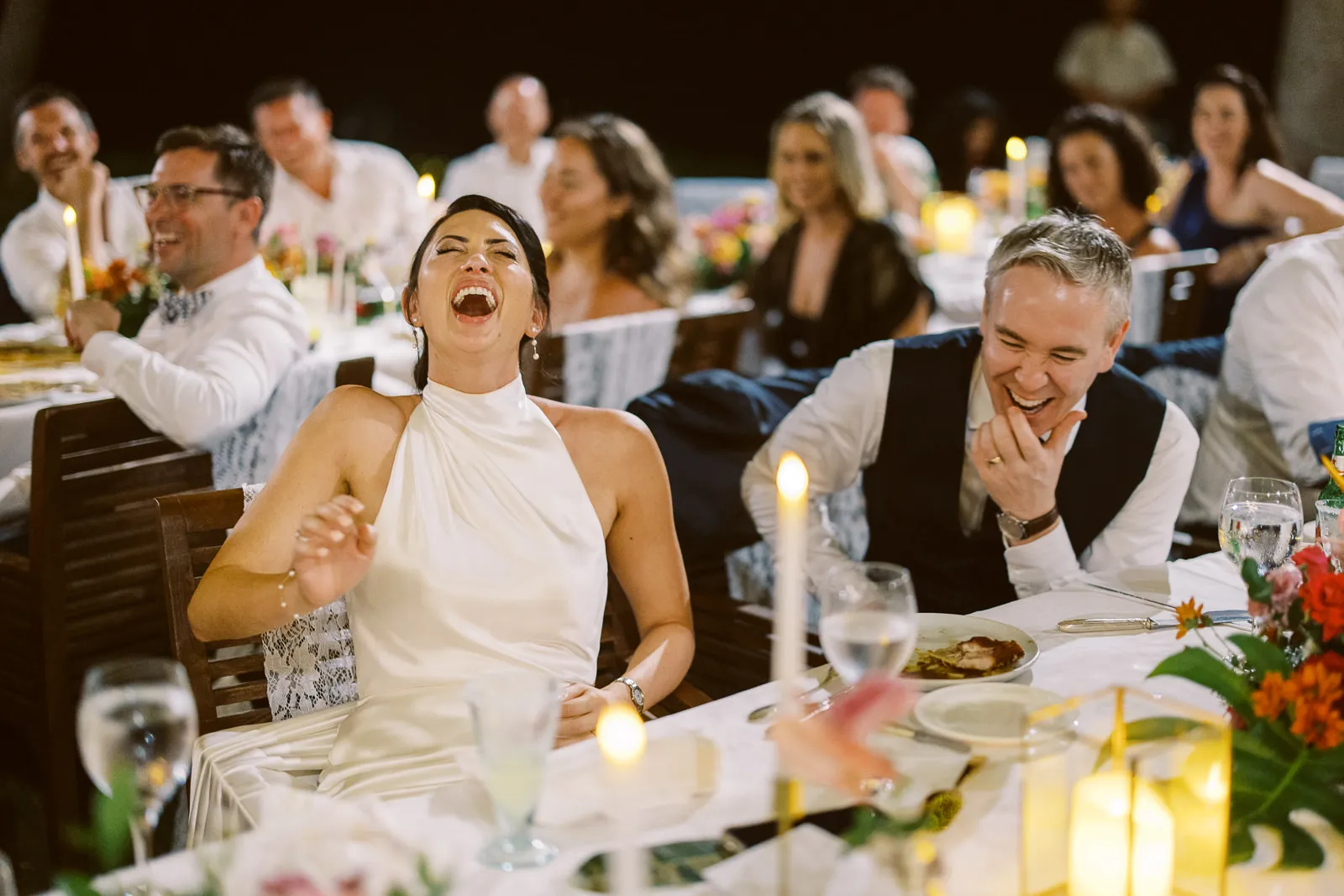 Bride and groom laughing hysterically during speeches at their Lombok wedding reception - candid photo by wedding photographer Lombok.
