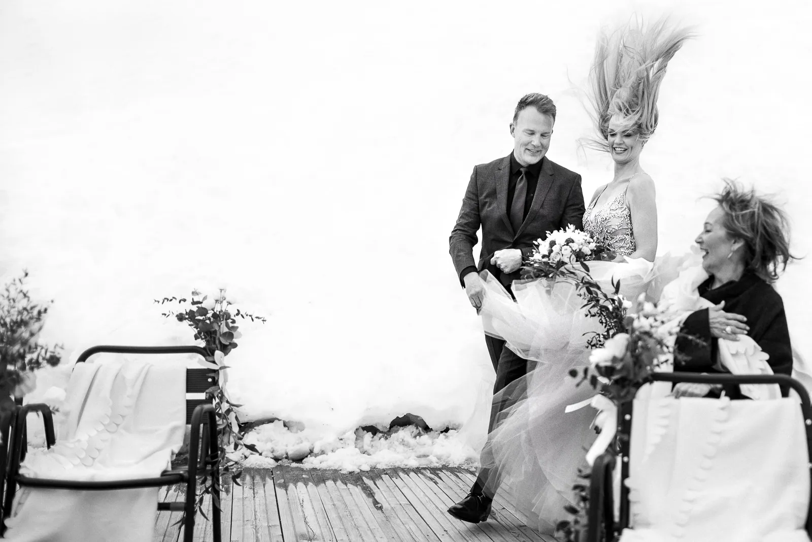 A candid black and white photo of a bride's veil flying in the wind during her outdoor wedding ceremony in Megeve, captured by a French Alps wedding photographer.