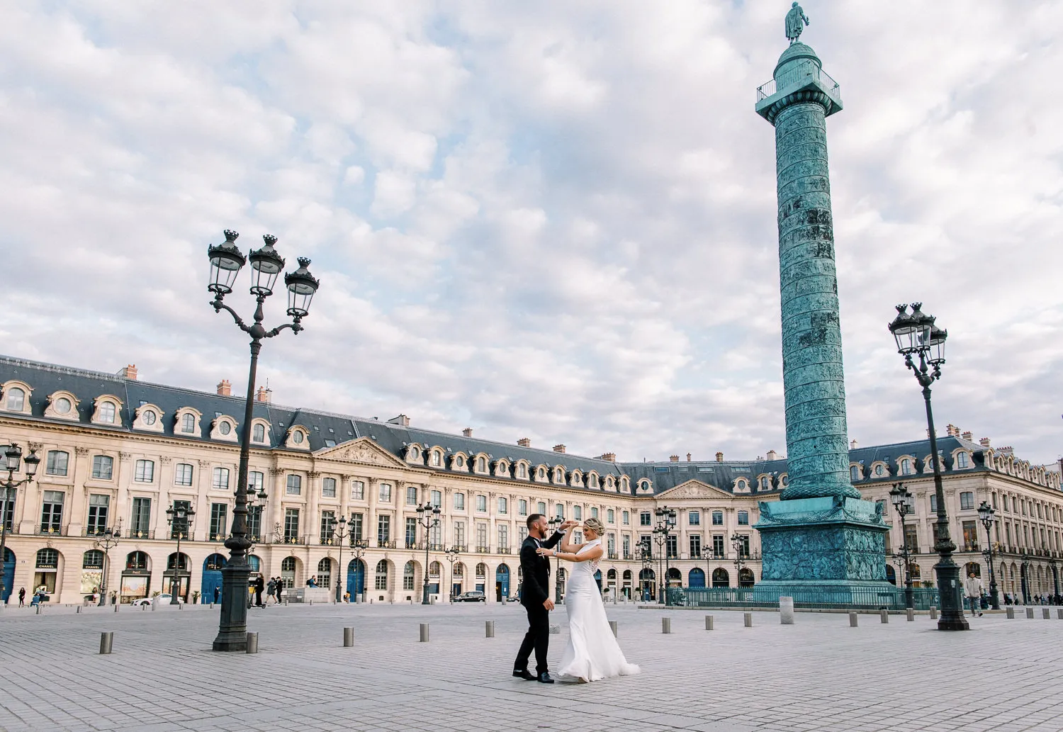Bride and groom dancing in the iconic Place Vendôme in Paris, near the Ritz Paris - photo by wedding photographer Ritz Paris. Photographe mariage Ritz Paris