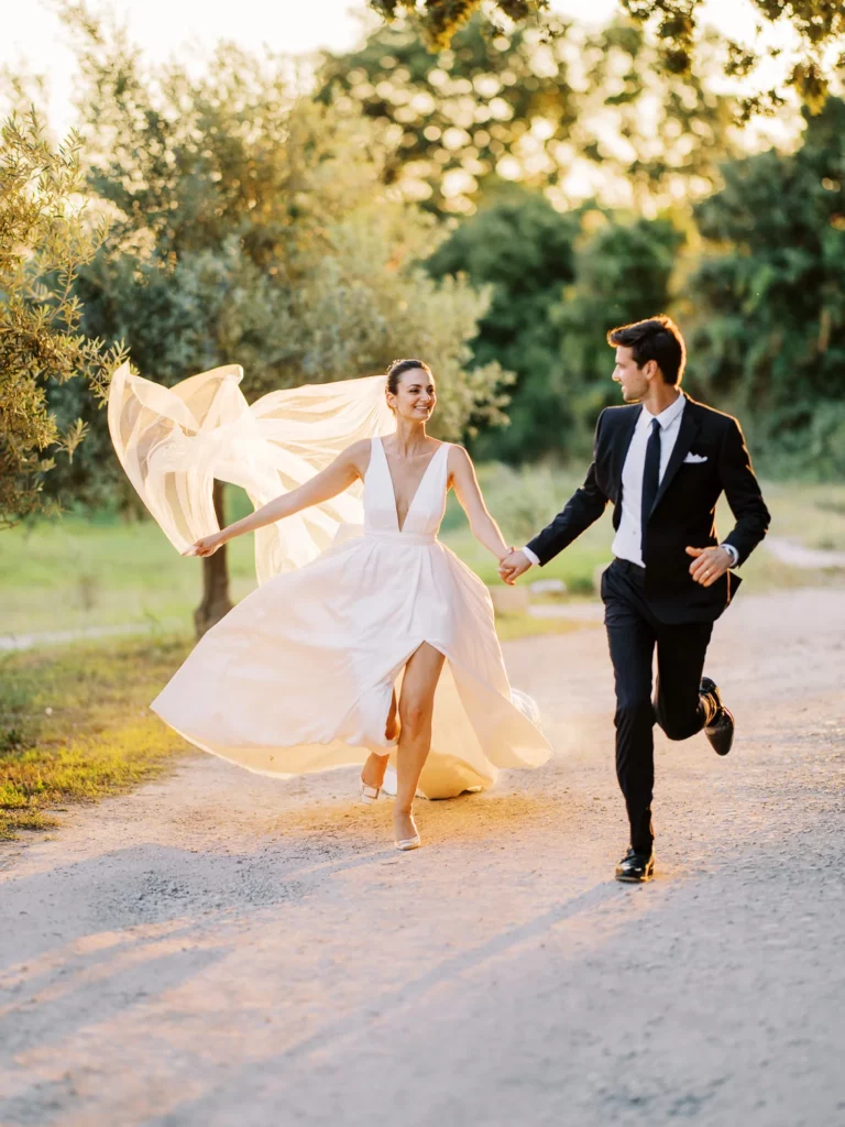 Un couple se tenant la maincourt en Provence dans la lumière du soleil tombante, capturé par le photographe mariage France Sylvain Bouzat.