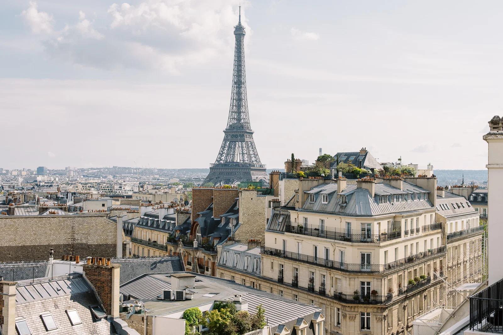 A stunning view of the Eiffel Tower and Parisian rooftops, an iconic backdrop for a Paris couple photo session. How Much Does a Photographer in Paris Cost?