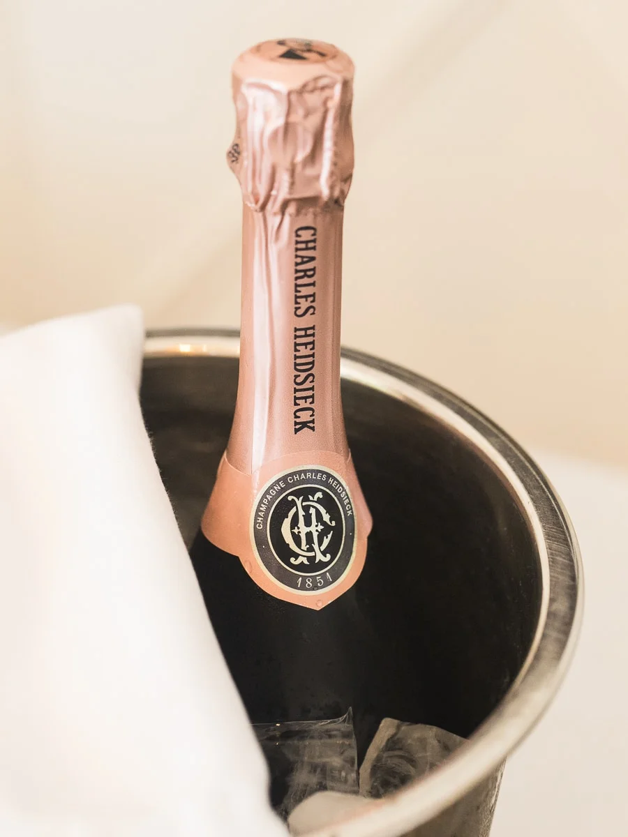A close-up of a bottle of Charles Heidsieck Rosé Champagne in a silver ice bucket.
