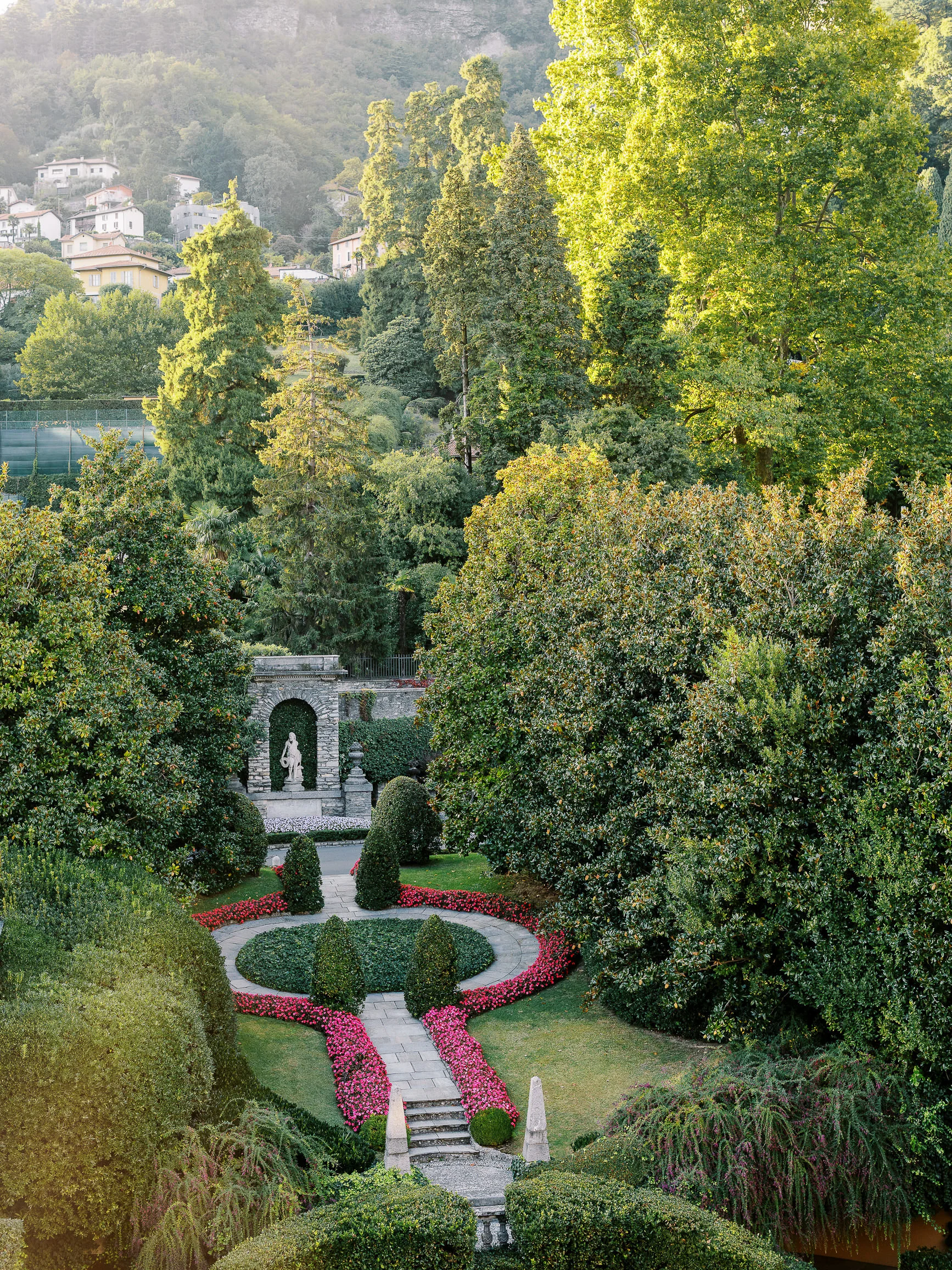 Lush Italian garden with classical statue and pink flowers, perfect for a Wedding photographer Lake Como.