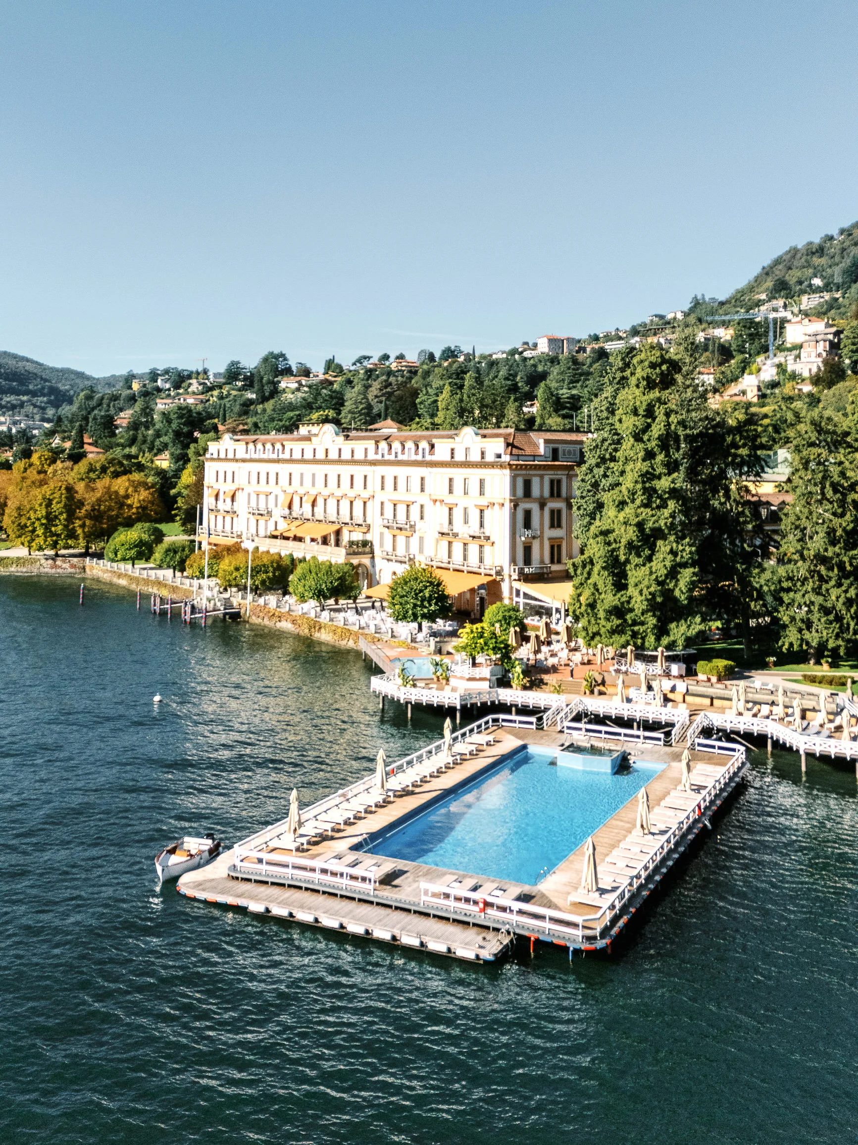 Aerial view of a luxurious lakeside hotel and floating pool on Lake Como by a wedding photographer Lake Como.