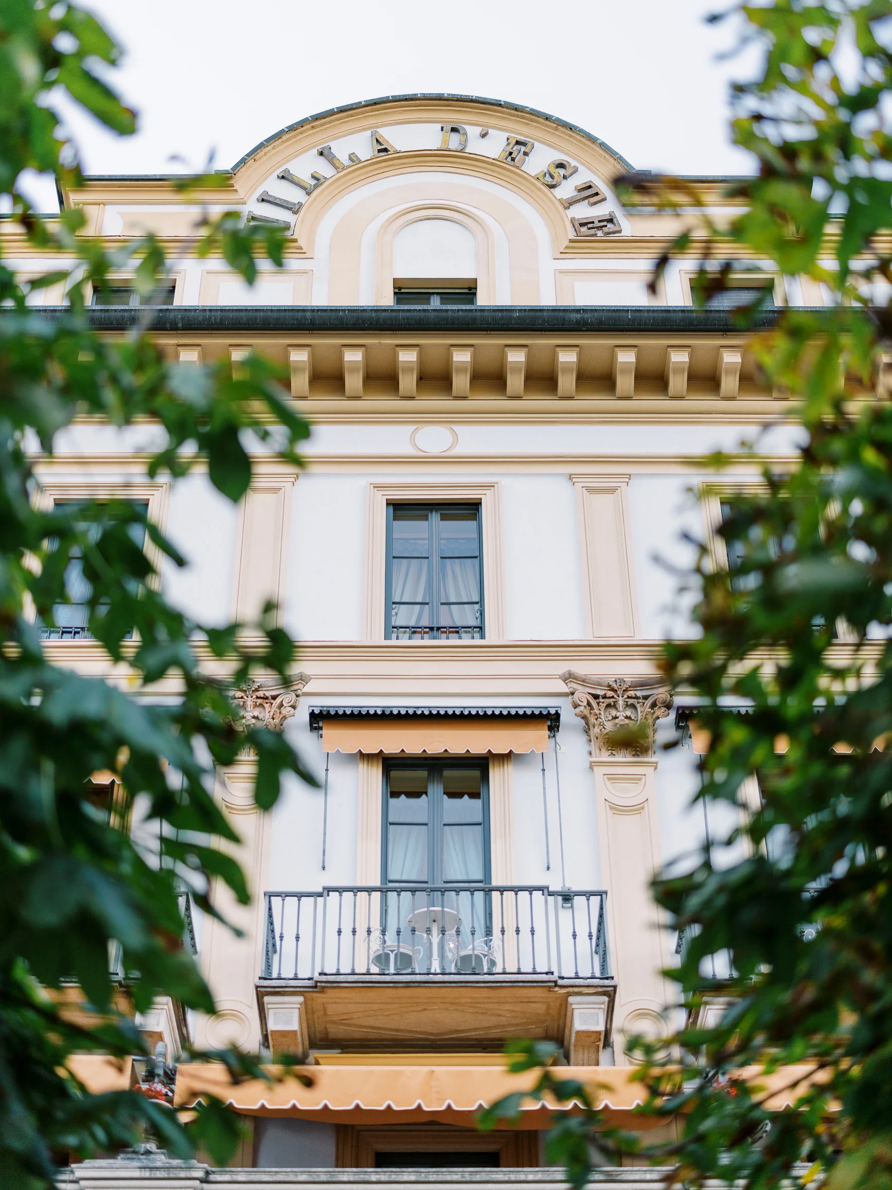 Elegant Villa d'Este facade with ornate balconies, captured by a Wedding photographer Lake Como. Photographe Mariage Lac de Côme.