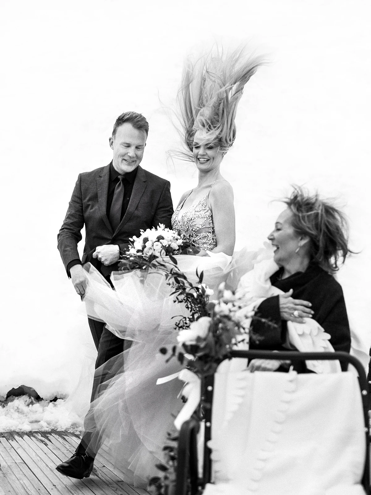 Joyful bride with wind-swept hair and groom laughing, captured by a Wedding photographer Crans-Montana.