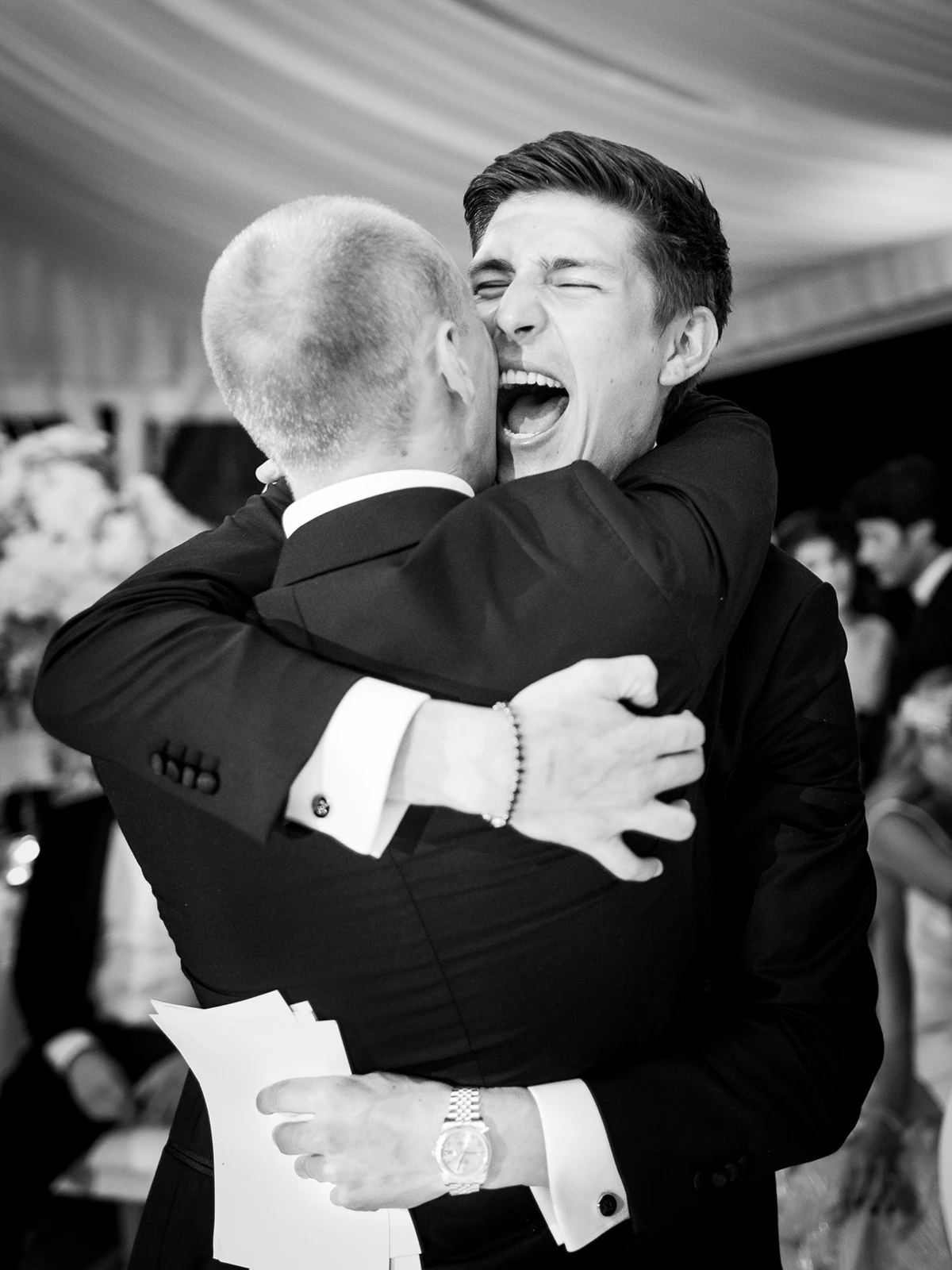 Emotional embrace between two men at a luxury wedding, captured by a Wedding photographer Crans-Montana.