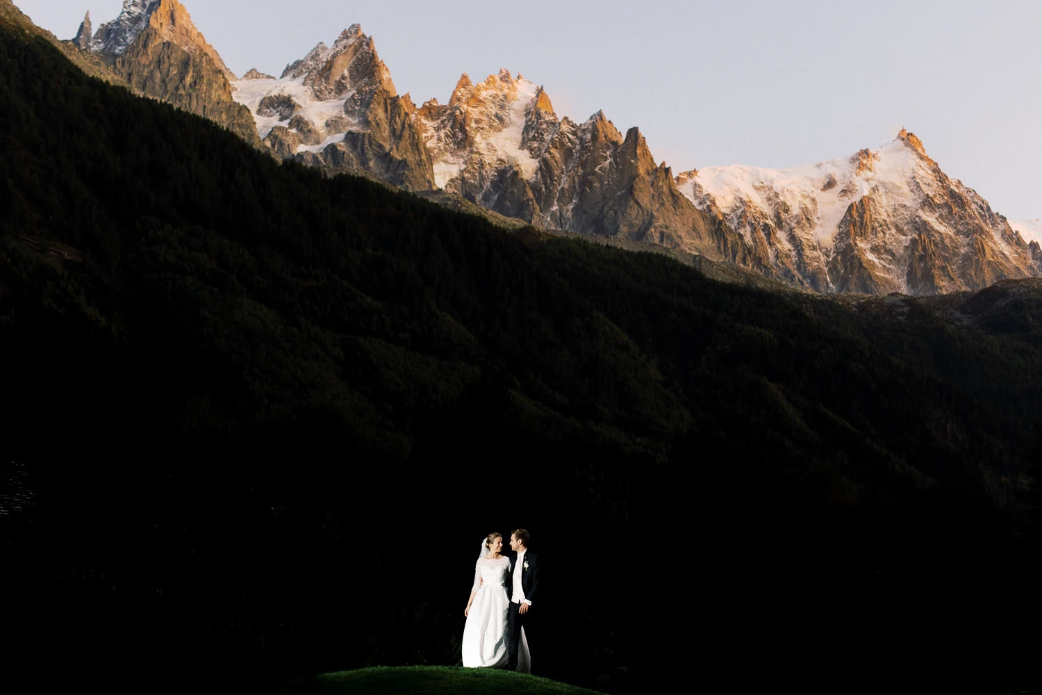 Wedding couple on a hill with dramatic snowy mountains, captured by Wedding photographer Crans-Montana.