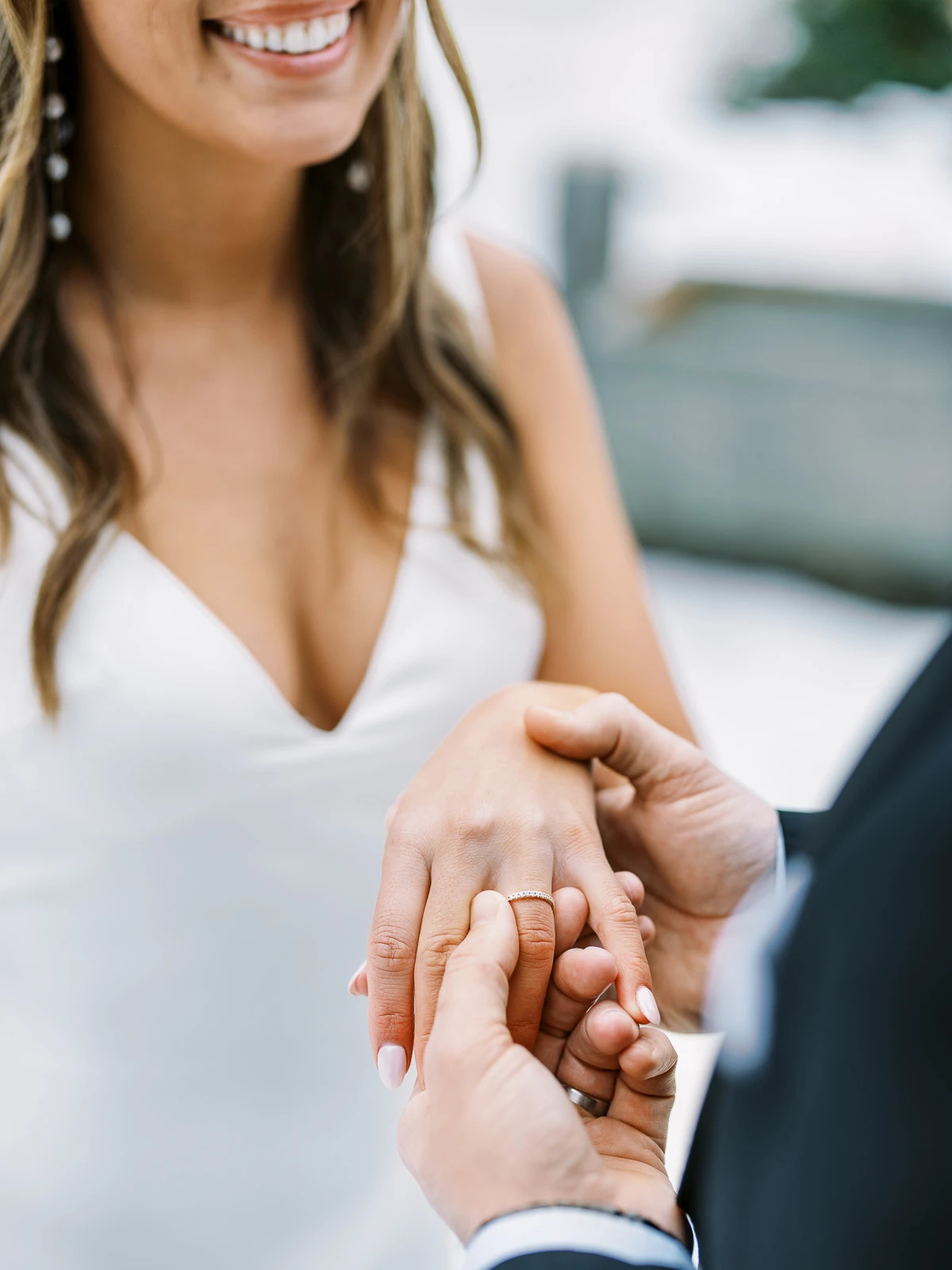 Groom places a diamond wedding ring on the bride's finger, French Alps wedding photographer.