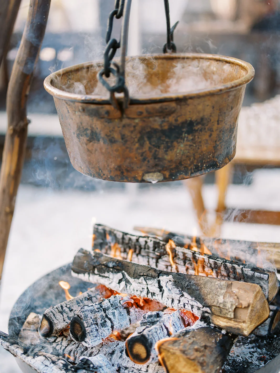 Rustic steaming pot over a warm campfire, captured by a wedding photographer French Alps.