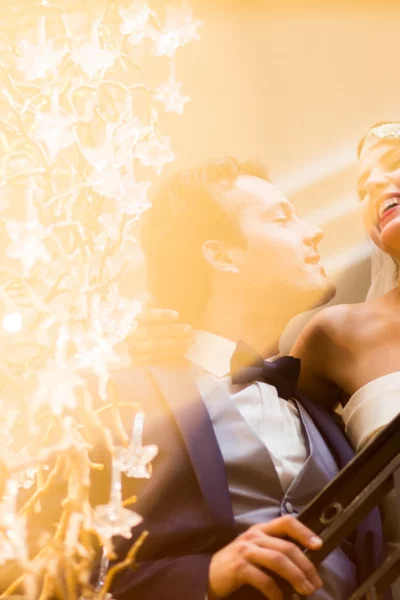 Joyful bride and groom on a grand staircase by a french wedding photographer.
