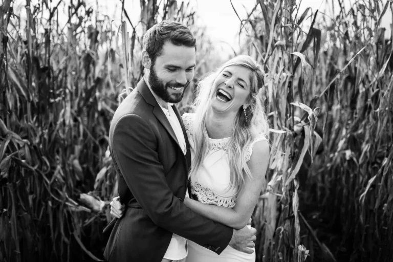 Couple joyeux riant lors d'une séance en extérieur avec un photographe de mariage.