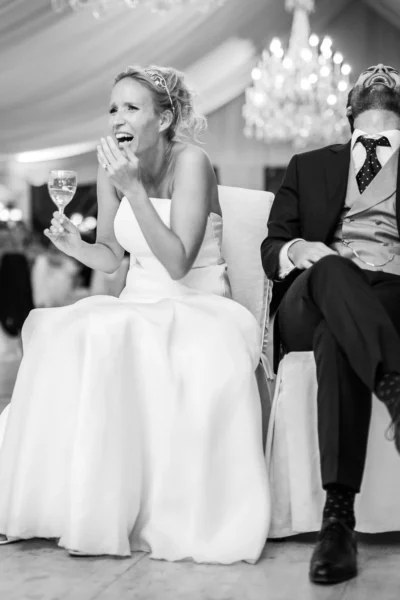 Joyful bride and groom laughing during their reception, captured by a french wedding photographer.