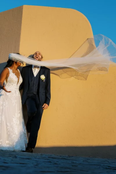 Candid bride and groom moment with blowing veil by a French wedding photographer.