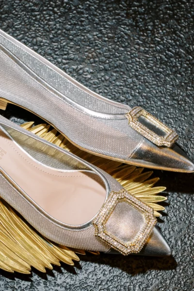 Silver mesh bridal shoes with crystal buckles captured by a French wedding photographer.