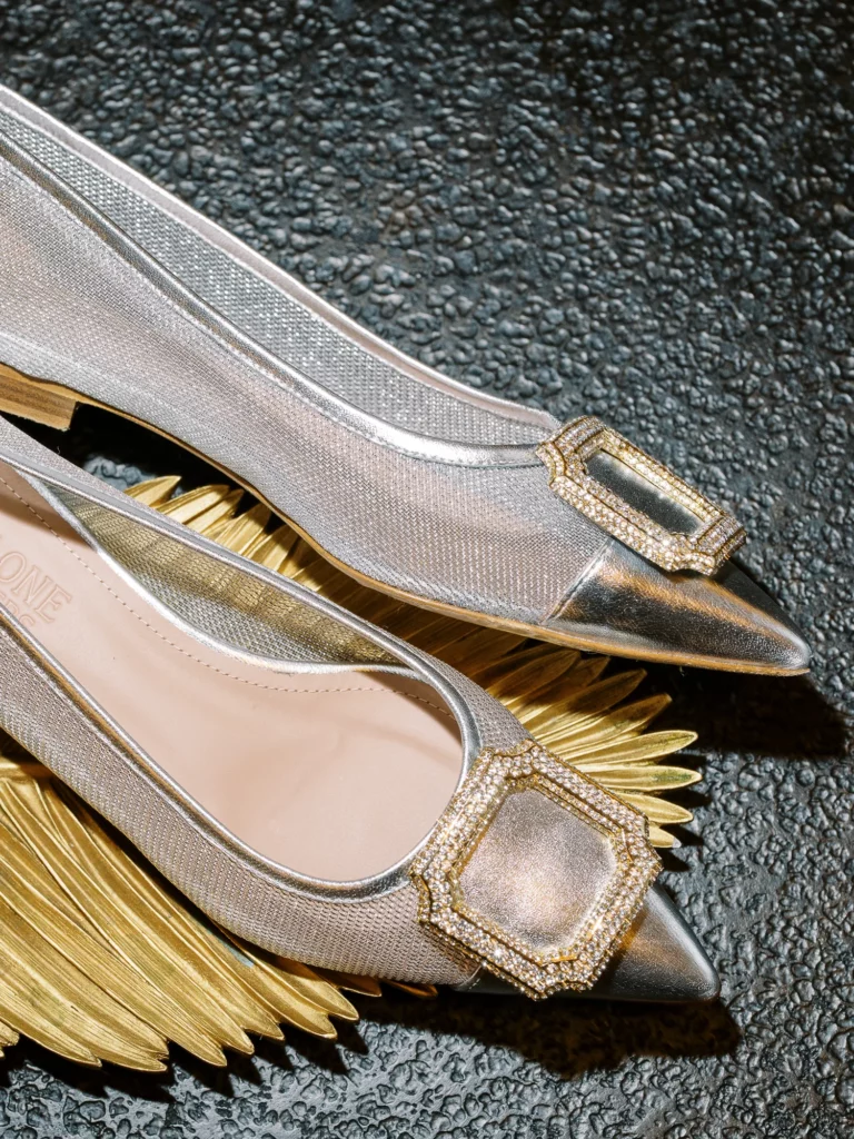 Silver mesh bridal shoes with crystal buckles captured by a French wedding photographer.