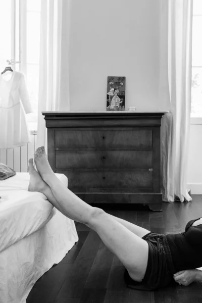 Bride reclining on the floor during preparation captured by a French wedding photographer.