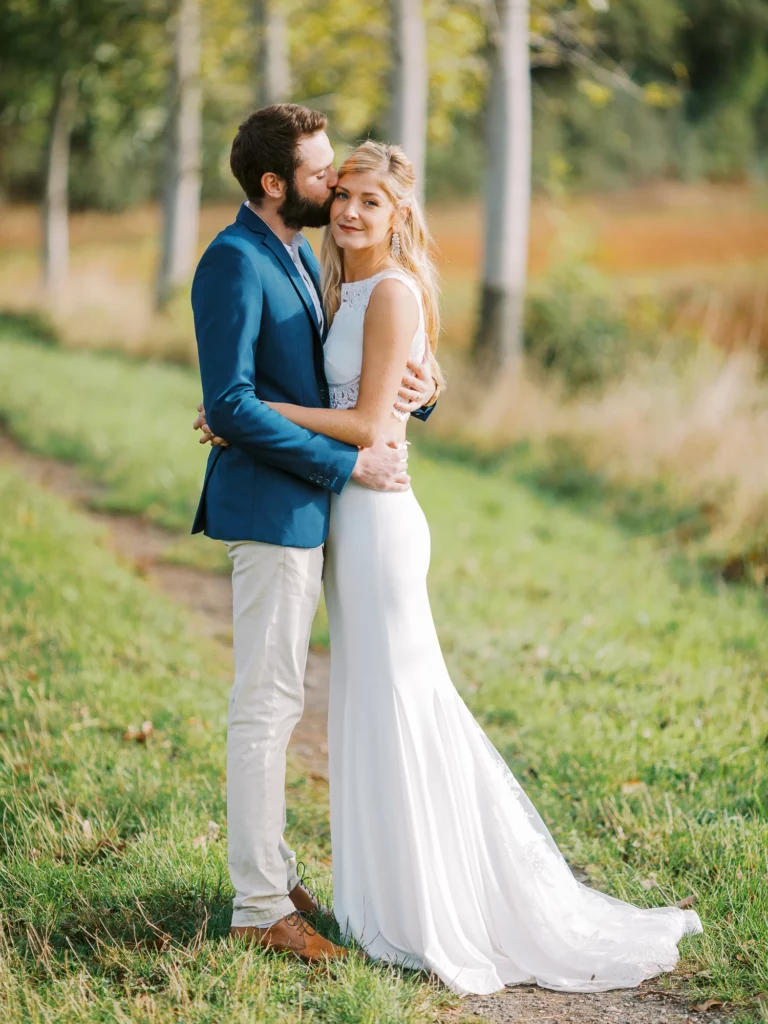 Une étreinte romantique capturée par un photographe lors d'une séance photo de couple en plein air.