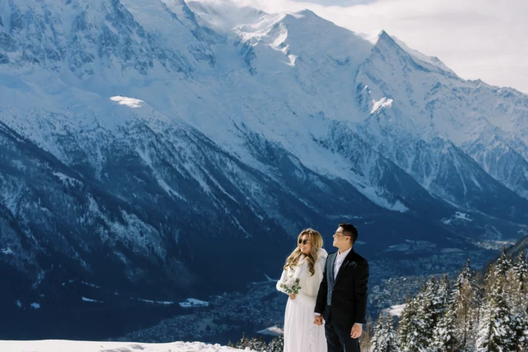 Couple devant les sommets enneigés pris par un photographe de mariage lors d'un elopement de luxe.