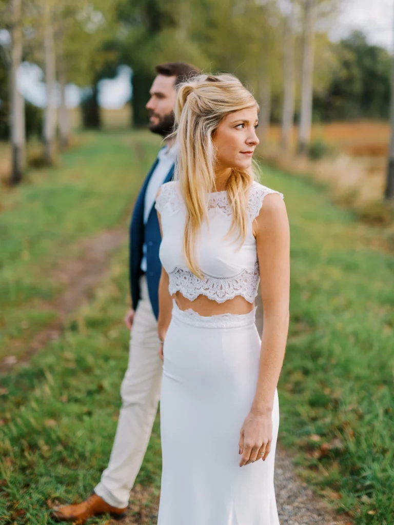 Mariée en ensemble de dentelle lors d'une séance photo de couple en extérieur.
