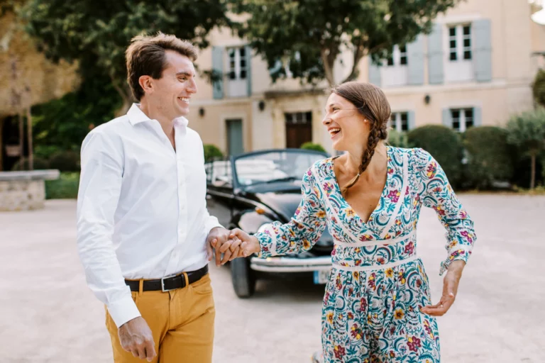 Couple riant et marchant main dans la main près d'une voiture vintage, photo de couple.