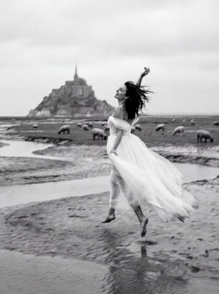 Bride jumping on the beach with Mont Saint-Michel background by a French wedding photographer.