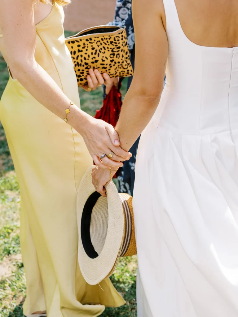 Bride and guest holding hands captured by a French wedding photographer in natural Provence light.