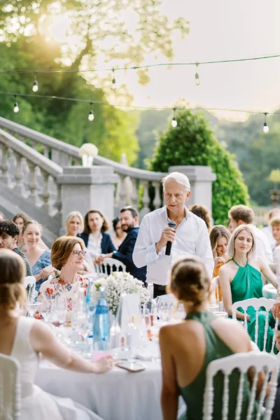 Wedding speech at an outdoor dinner by a french wedding photographer during golden hour.