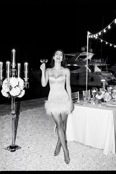 Candid bride with champagne at a luxury harbor reception by a french wedding photographer.