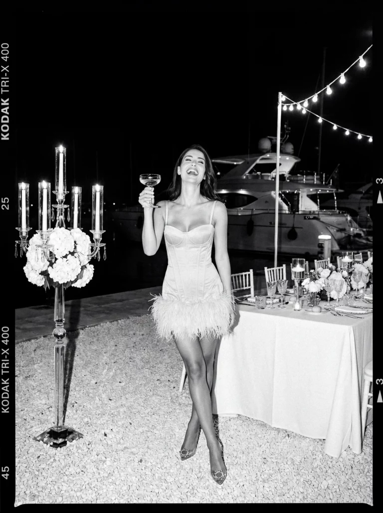 Candid bride with champagne at a luxury harbor reception by a french wedding photographer wedding photographer.