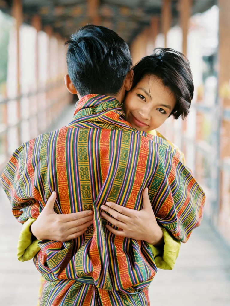 Un couple s'enlaçant en tenue traditionnelle capturé par un photographe de mariage spécialisé en photo de couple.