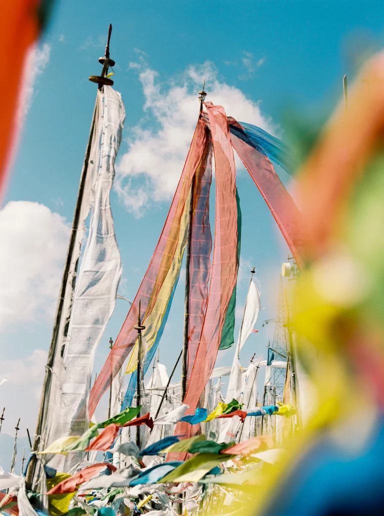 Drapeaux de prière vibrants sur fond de ciel bleu capturés par un photographe de mariage lors d'un elopement.