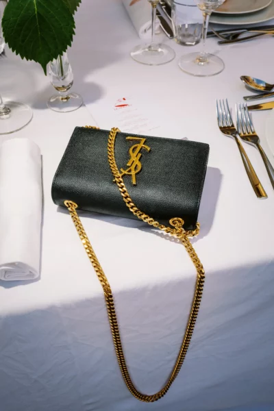 Black Yves Saint Laurent bag on a luxury table captured by a French wedding photographer .