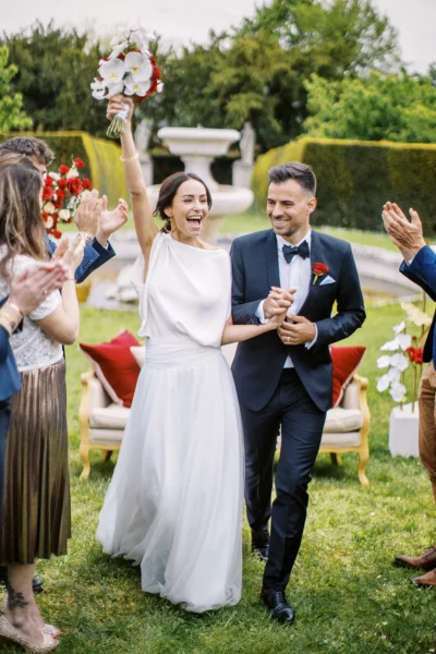 Joyful bride and groom walking through guests, captured by a French wedding photographer.