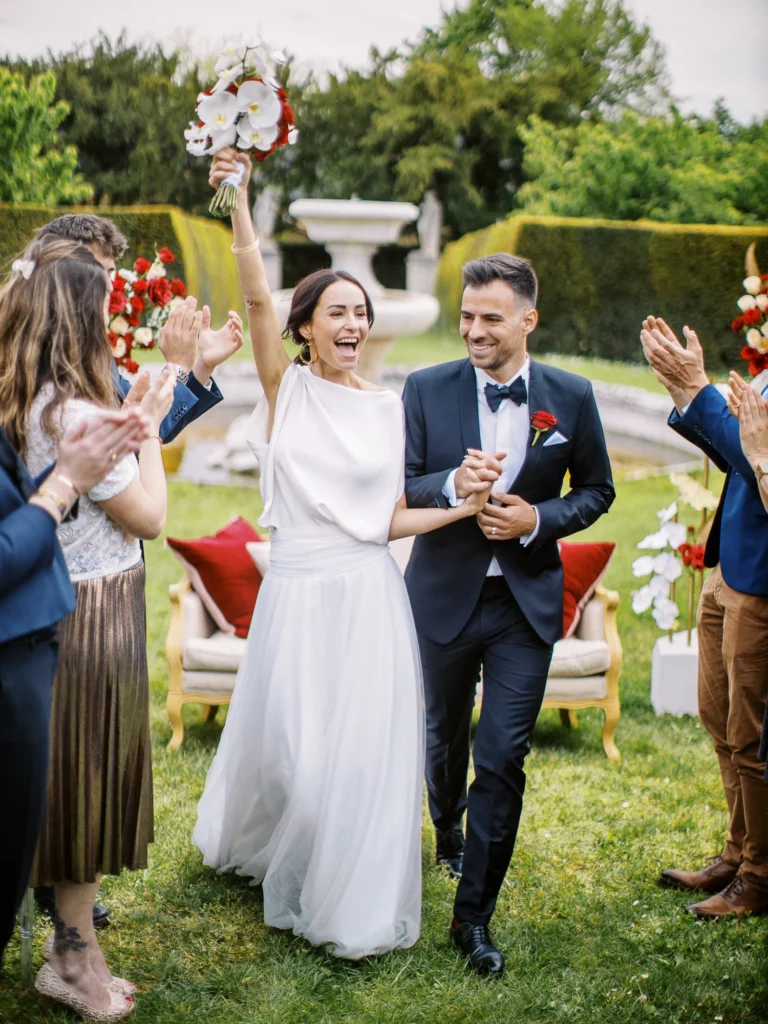 Joyful bride and groom walking through guests, captured by a French wedding photographer.
