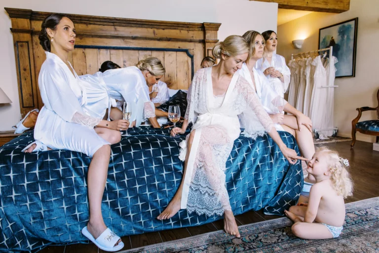 Bride and bridesmaids in silk robes during morning preparation by a French wedding photographer.