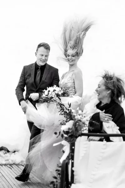 A joyful bride with wind-blown hair at a snow-covered venue by a French wedding photographer.
