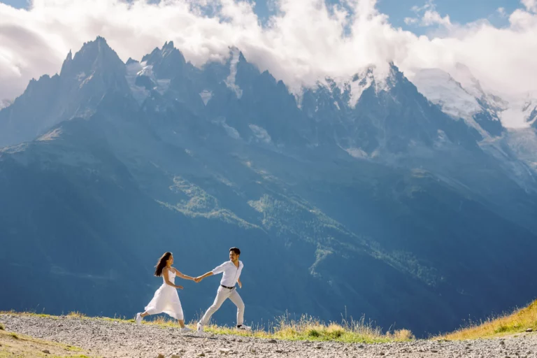 Couple courant dans les Alpes, capturé par un photographe de mariage lors d'un elopement en montagne.