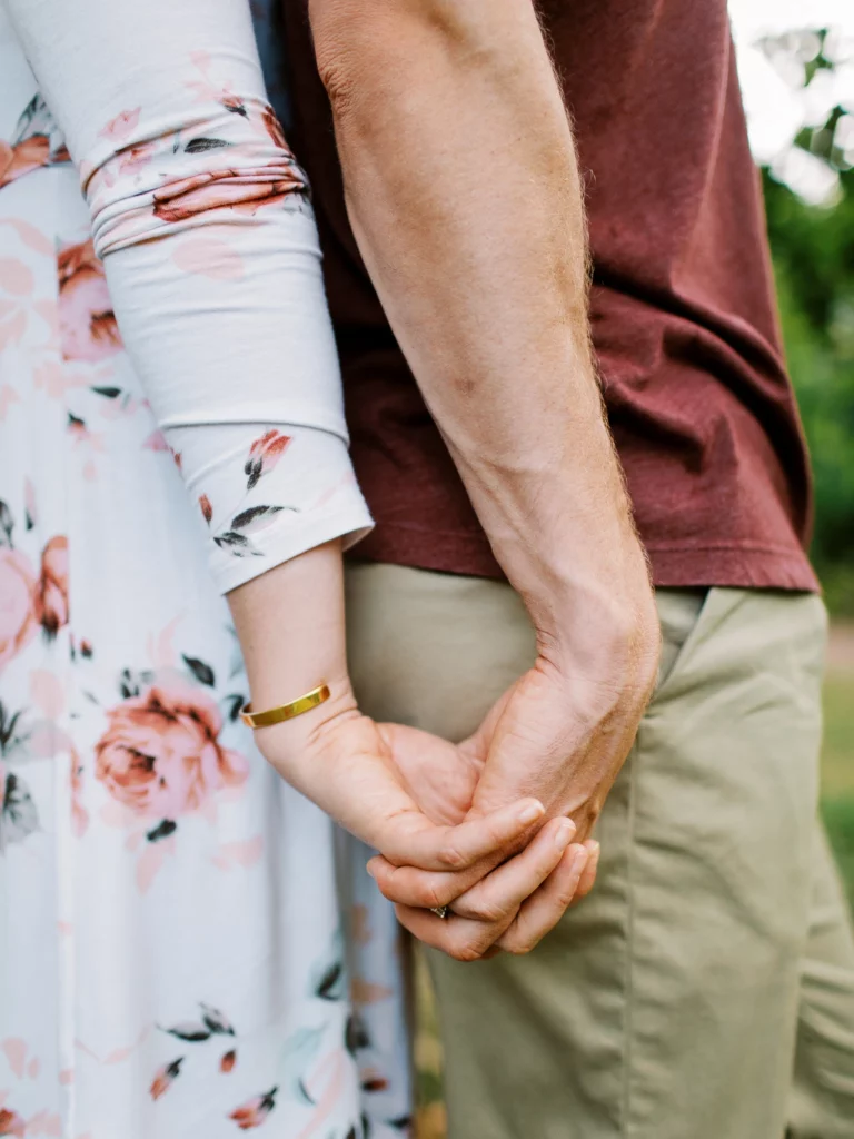 Gros plan de mains par un photographe de couple pour une demande en mariage intime.