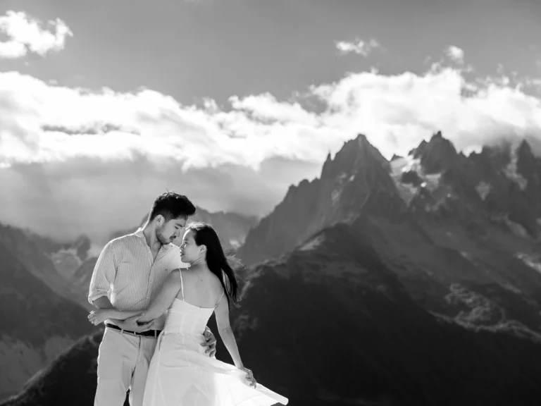 Étreinte en montagne capturée en noir et blanc par un photographe de mariage de couple lors d'un elopement.